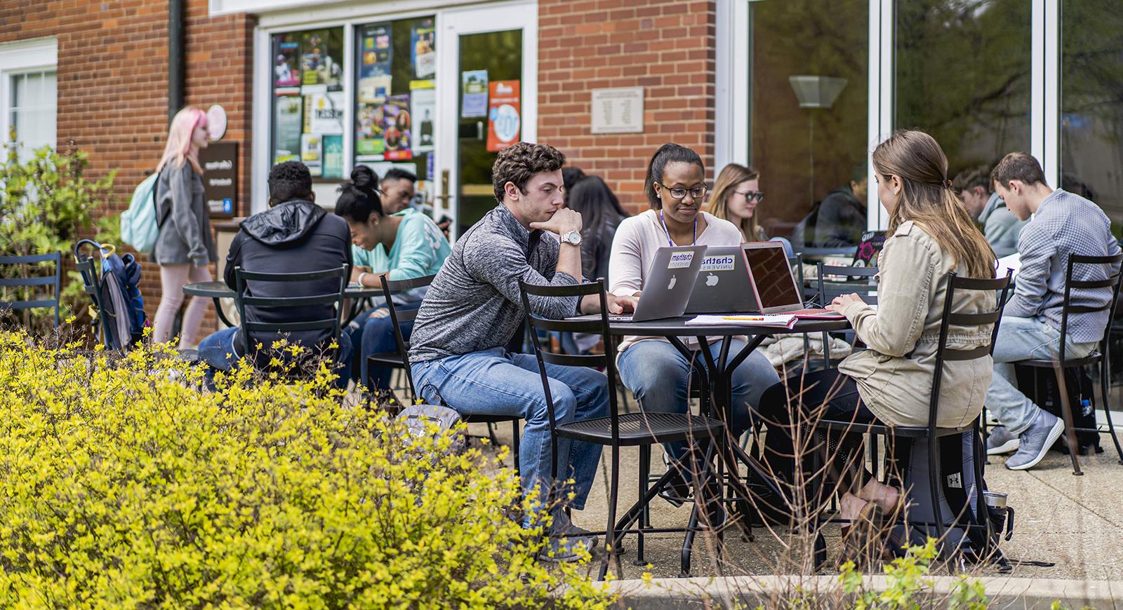 Photo of Chatham University students working on outdoor patio tables in front of Cafe Rachel on the 欧洲杯官方投注网站.